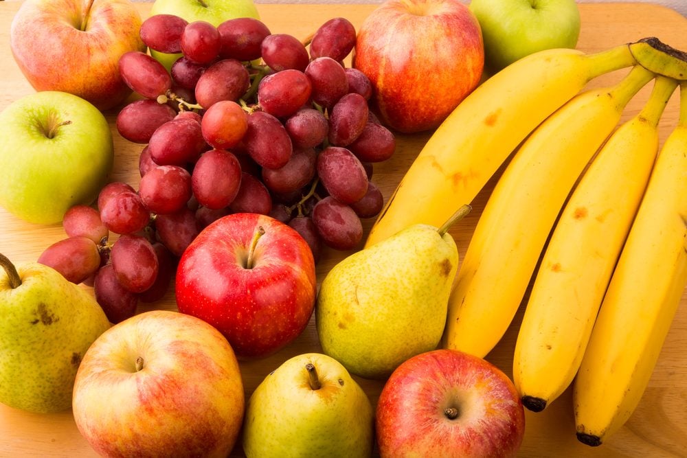 나무 테이블에 신선한 바나나, 배, 사과, 포도의 근접 촬영