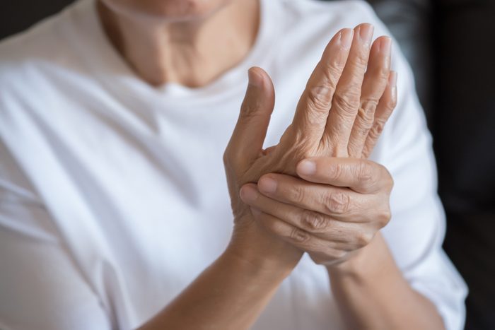 senior woman holding hand with arthritis pain