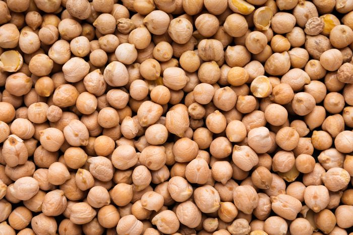 Food background from raw uncooked chickpeas, top view, closeup