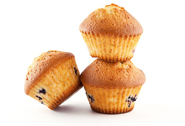 Tasty muffins with blueberry on white background