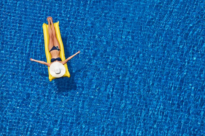 woman floating in pool on an inflatable raft
