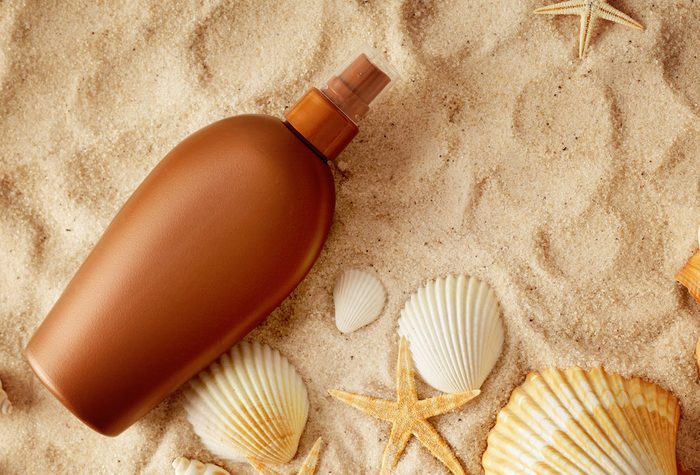tanning lotion in sand with shells