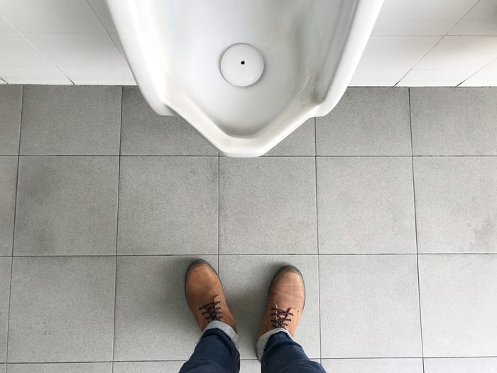 Man standing in front of urinalTop view of a man legs in front of urinal in men toilet