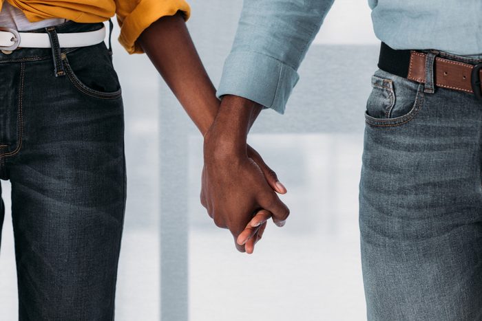 cropped image of african american couple holding hands at home