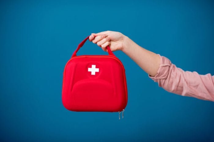 Holding first aid kit on the blue background