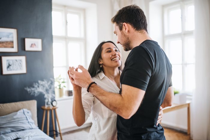couple dancing at home together smiling
