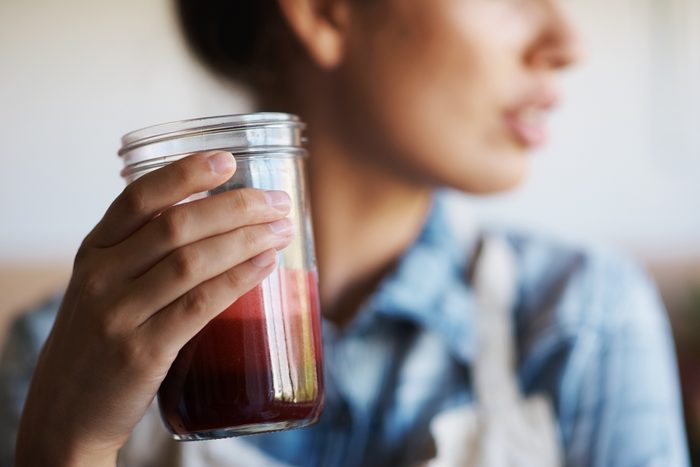 close up of woman holding healthy juice in glass