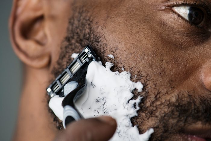 Black man shaving his beard