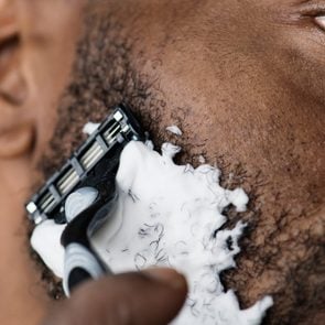 Black man shaving his beard