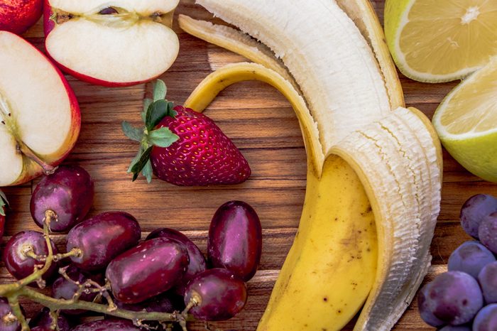Fresh fruits: banana, grapes, lemon, and apple