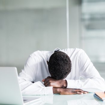 Tired African American employee in formal wear fall asleep after long working hours in office