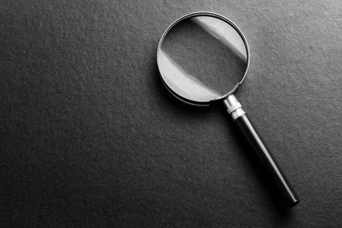 magnifying glass on black texture background.