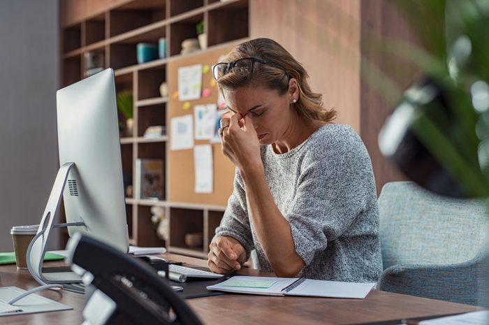 woman with anxiety headache trying to work