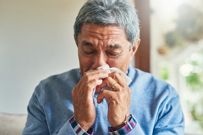senior man sick with a cold at home