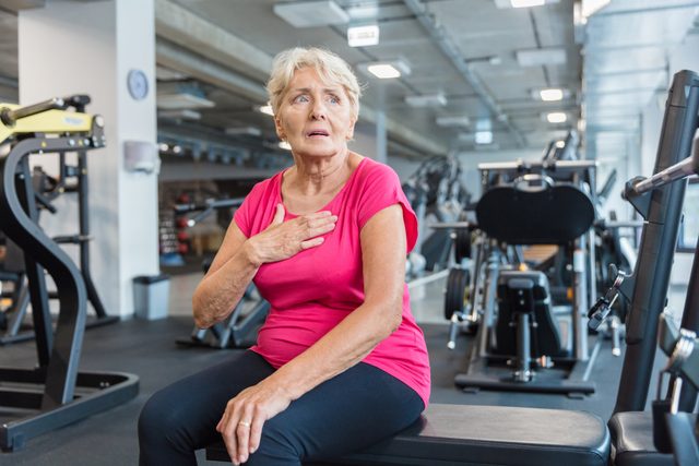 woman suffering from shortness of breath in the gym