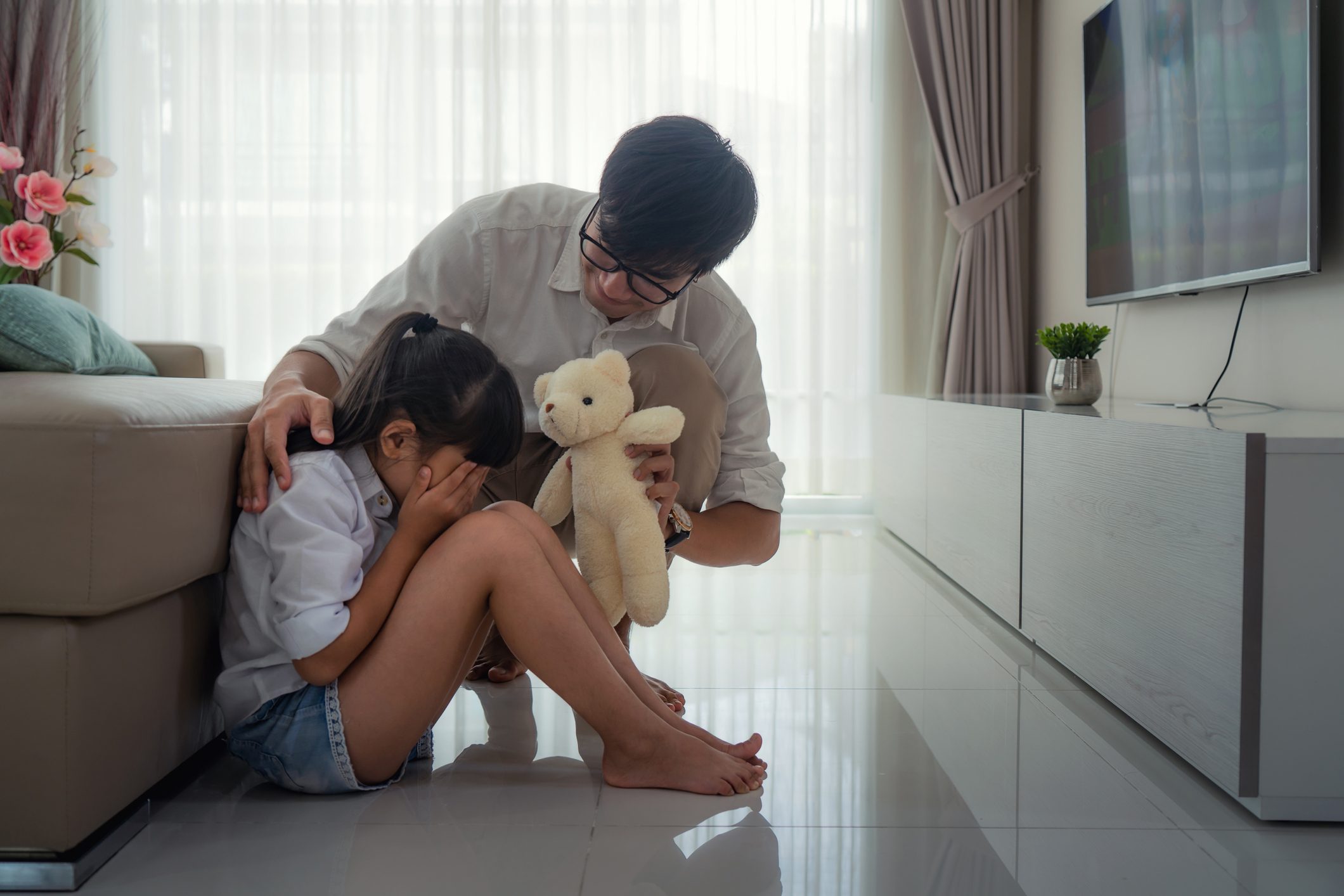 father trying to comfort crying daughter