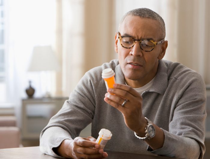 man looking at prescription pill bottle