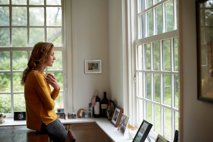 woman in home kitchen looking out window