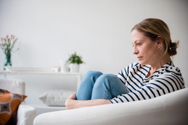 woman sitting in chair at home thinking