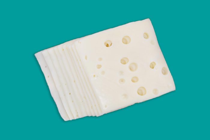 Top view of several slices of low sodium Swiss cheese.