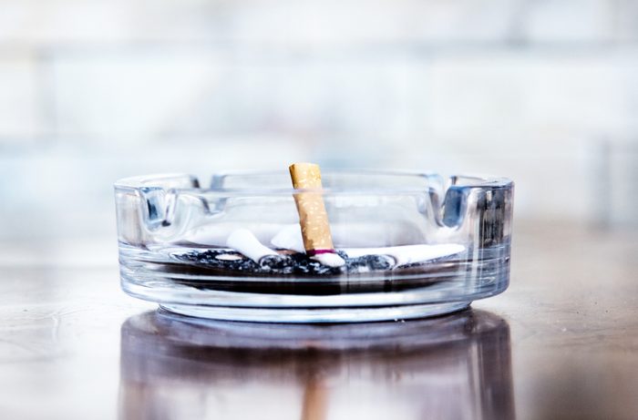 Cigarette butts and ashtray in a glass
