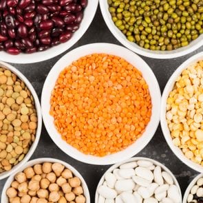 Assortment of beans (red lentil, green lentil, chickpea, peas, red beans, white beans, mix beans, mung bean) on gray background. Top view. Food background