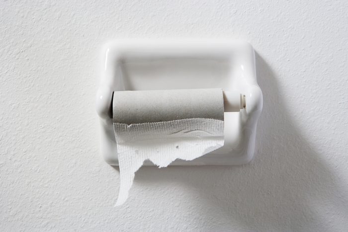 empty toilet paper roll on white wall