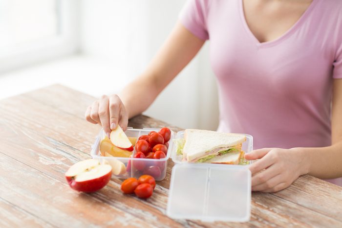Woman with lunch packed in containers with divided sections. 