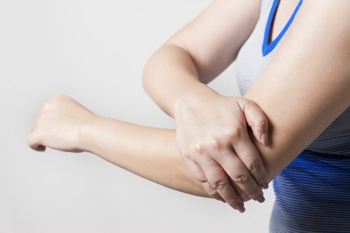 Woman holding arthritic elbow