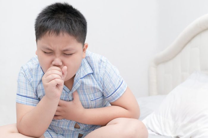 Boy coughing on bed