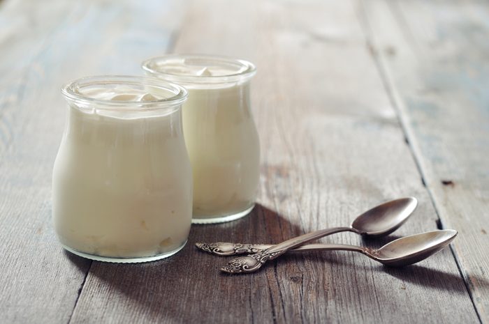 two jars of plain yogurt with two spoons
