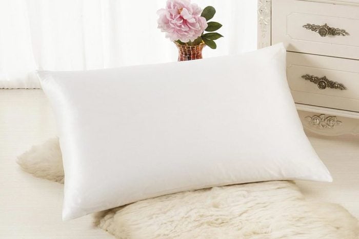Silk white pillowcase in a bedroom.