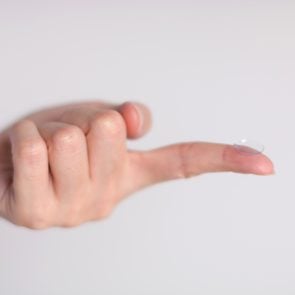 Close-up of a hand that index finger have contact lens at a tip (selective focus). 
