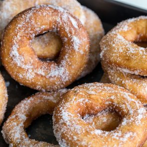 Homemade donuts with sugar and sugar powder in old metal background. 