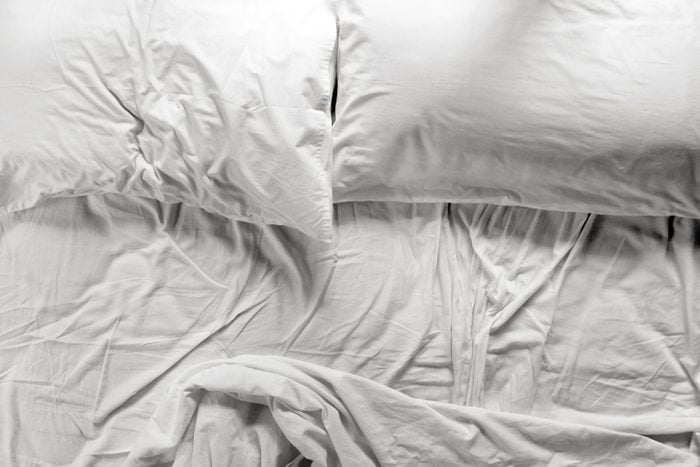 unmade bed with two pillows