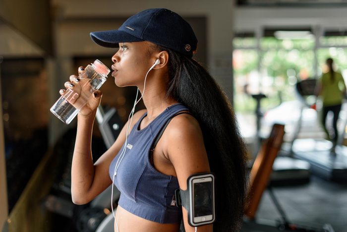 woman drinking water at gym