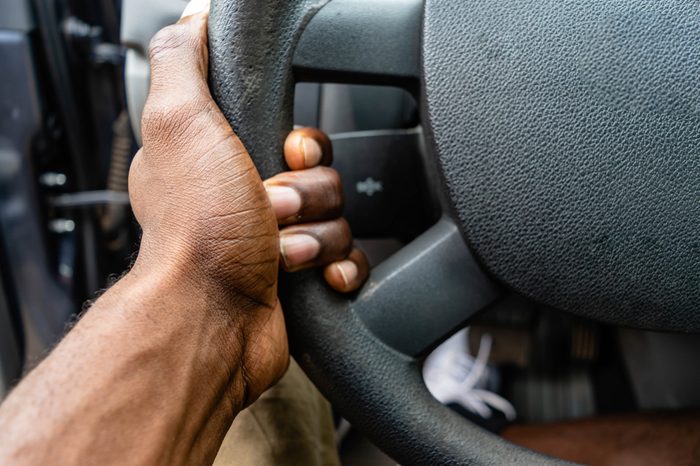 Hand holding steering wheel