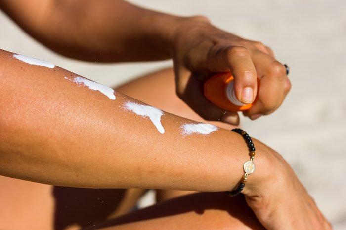 woman applying sunscreen on arm