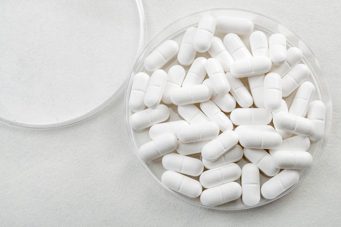 White medical pills in a petri dish.