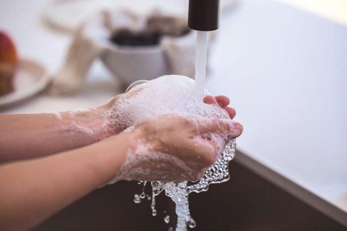 washing hands with soap and water in sink