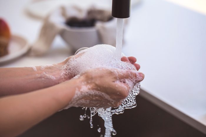 washing hands with soap and water in sink