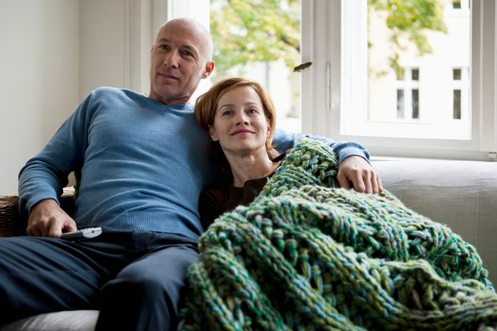 couple sitting on couch at home watching television