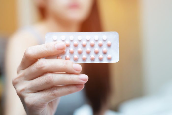 Contraceptive Pill Woman hands opening birth control pills