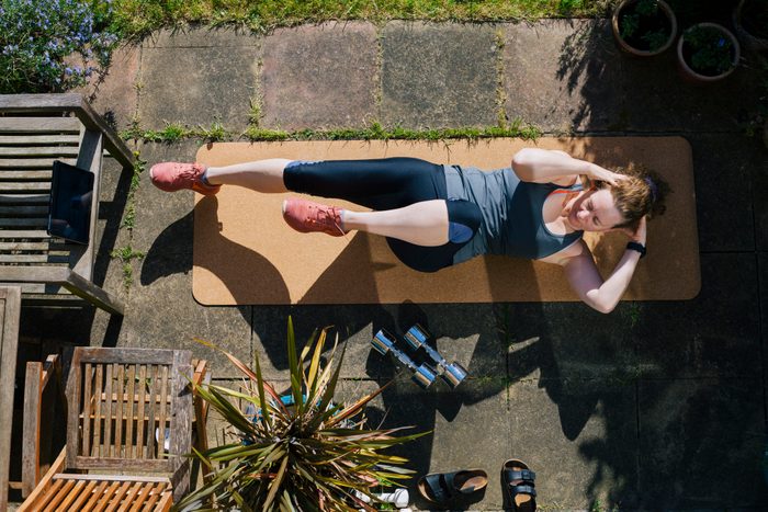 overhead view of woman working out on exercise mat outside