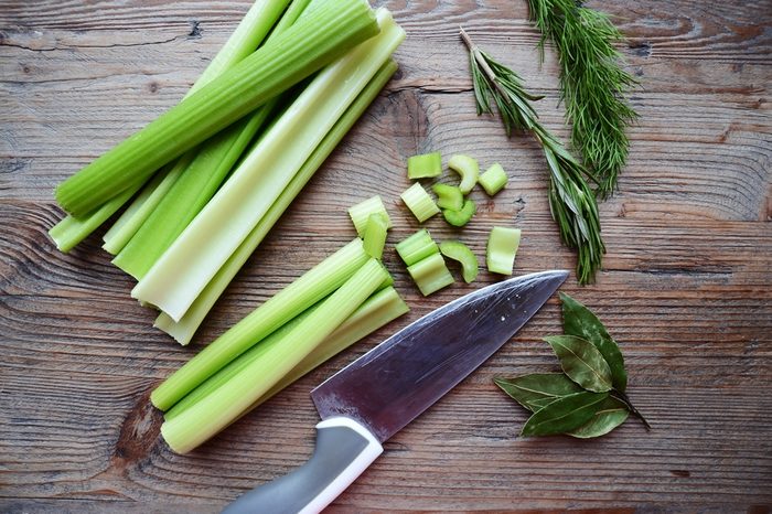 Celery Sticks on a cutting board with dill and rosemary