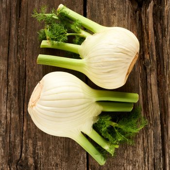 fresh fennel leaning on an old wooden table