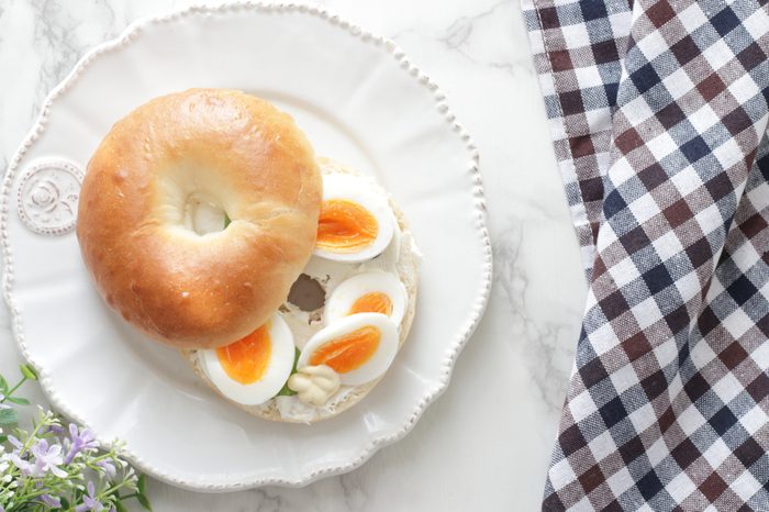 Homemade soft boiled egg and cream cheese bagel sandwich