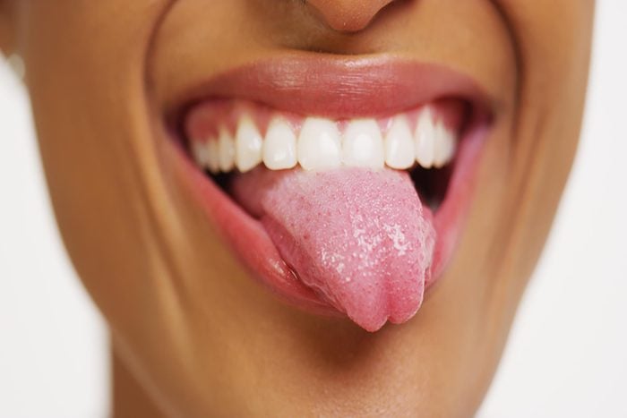 Close up of woman with white teeth smiling and sticking tongue out