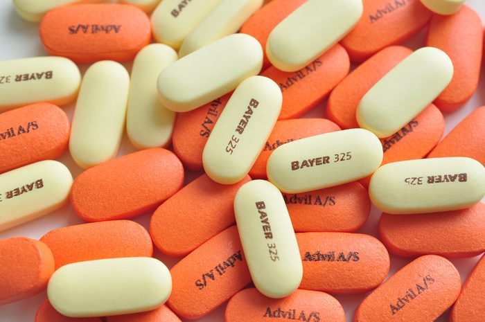 Bayer and Advil pills on white background