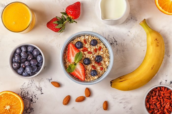 Healthy breakfast - a bowl of oatmeal, berries and fruit, orange juice, milk.